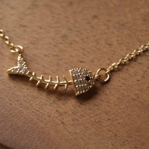 COLLAR OLAS Y HUESOS DORADO